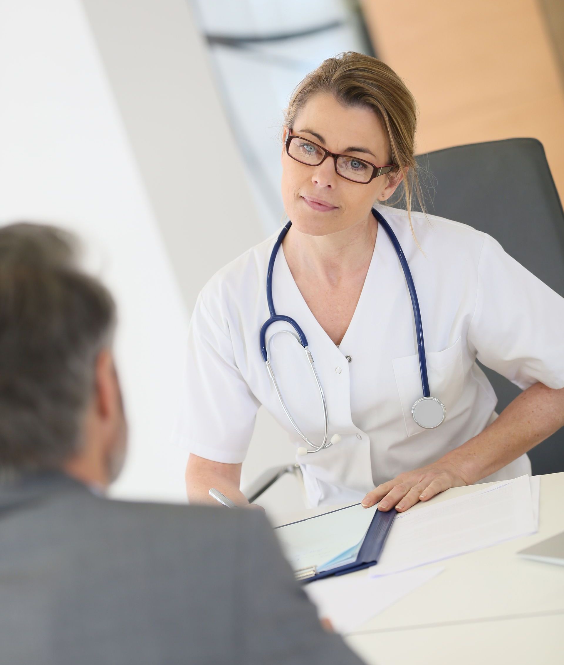 Un médecin avec un stéthoscope autour du cou parle à un patient