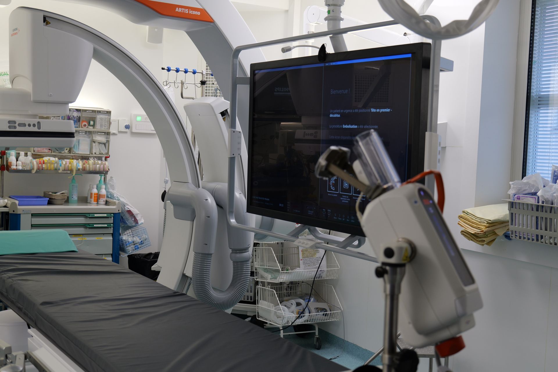 Une chambre d'hôpital avec un lit, un moniteur et d'autres équipements médicaux.