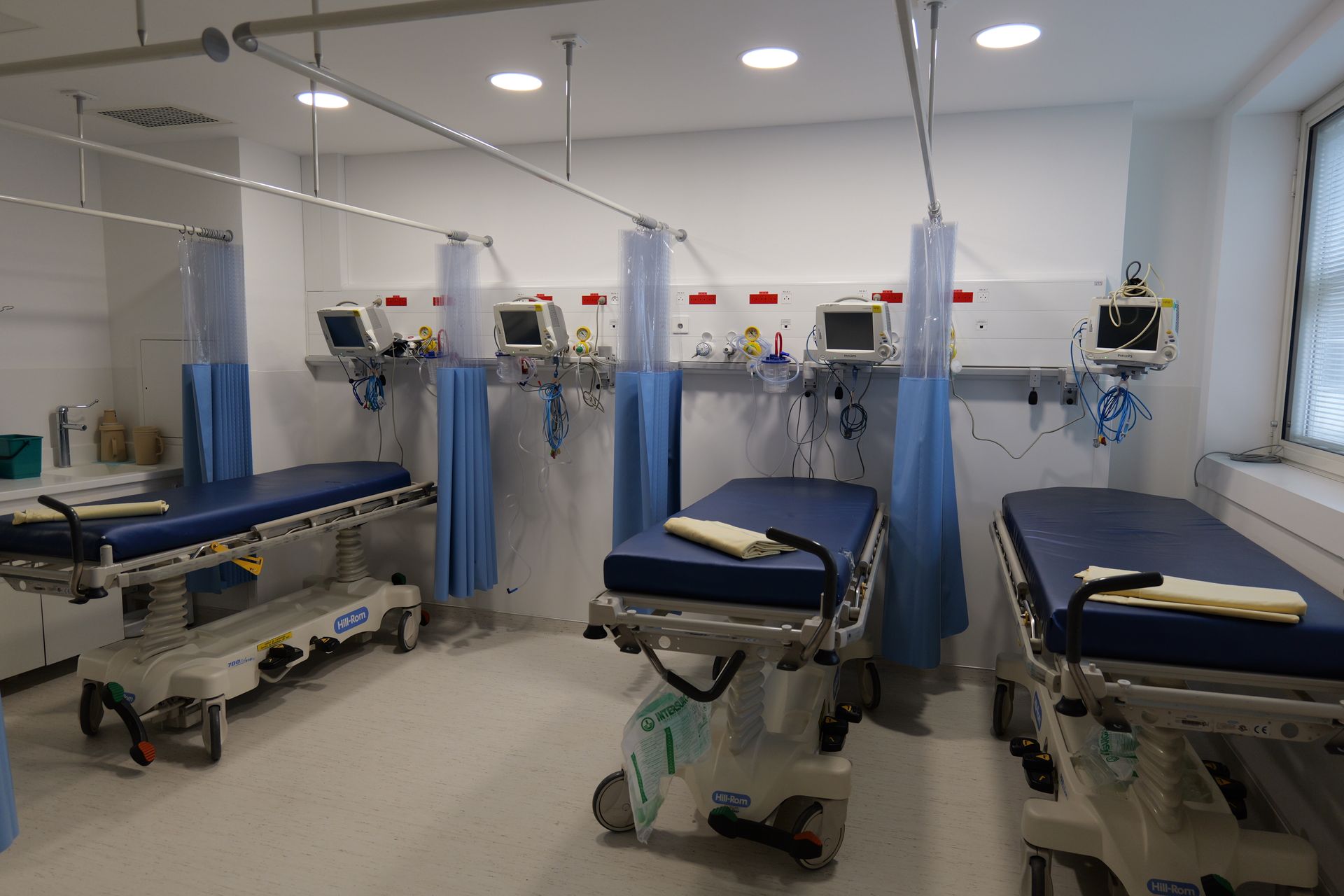 Une chambre d'hôpital avec beaucoup de lits et de moniteurs.