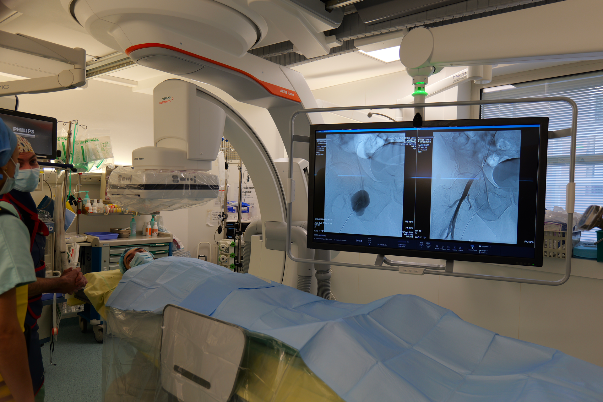 Un chirurgien se tient à côté d'un moniteur dans une salle d'opération.