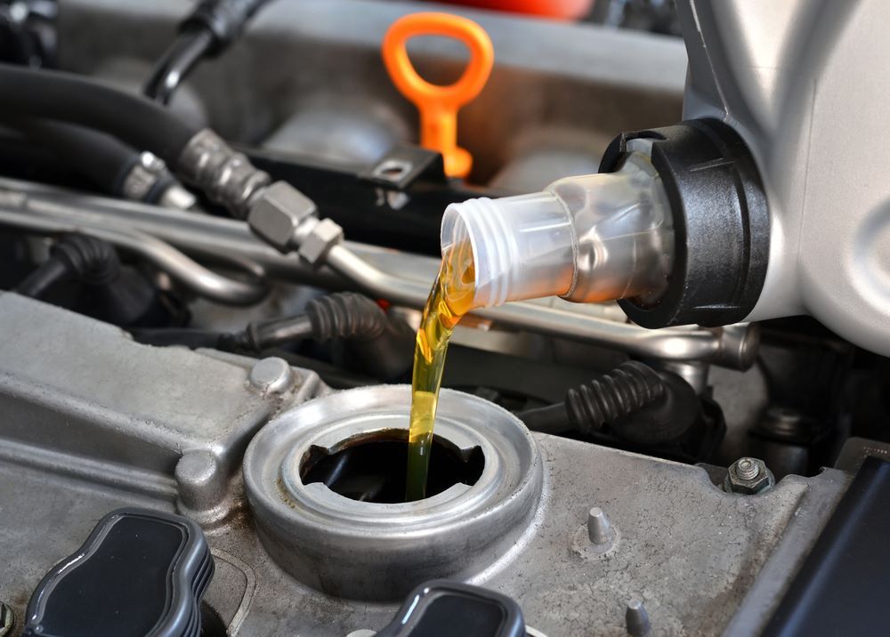 A Close Up of a Person Pouring Oil Into a Car Engine — P & R Automotive Services in Pialba, QLD 