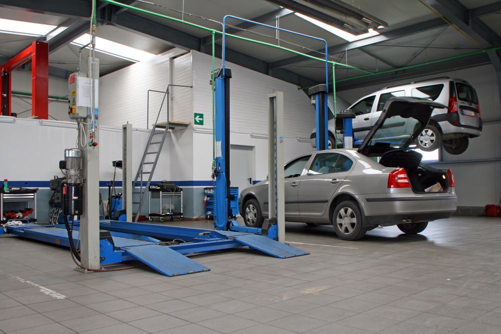 Two Cars Are Sitting on a Lift in a Garage — P & R Automotive Services in Pialba, QLD 