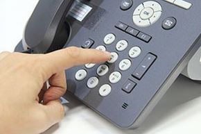 a person is pressing a button on a telephone .