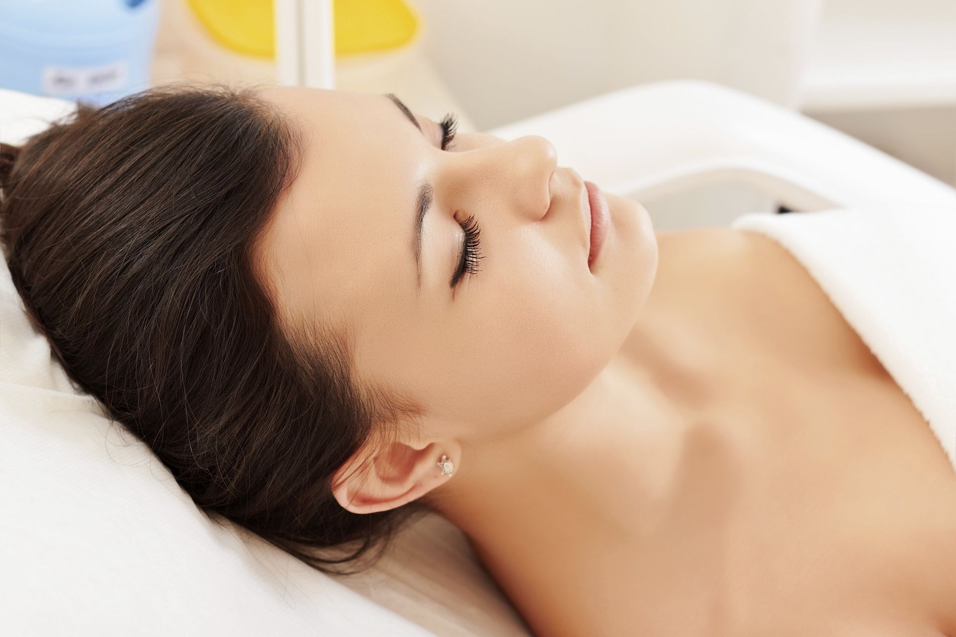 a woman is laying on a bed with her eyes closed .