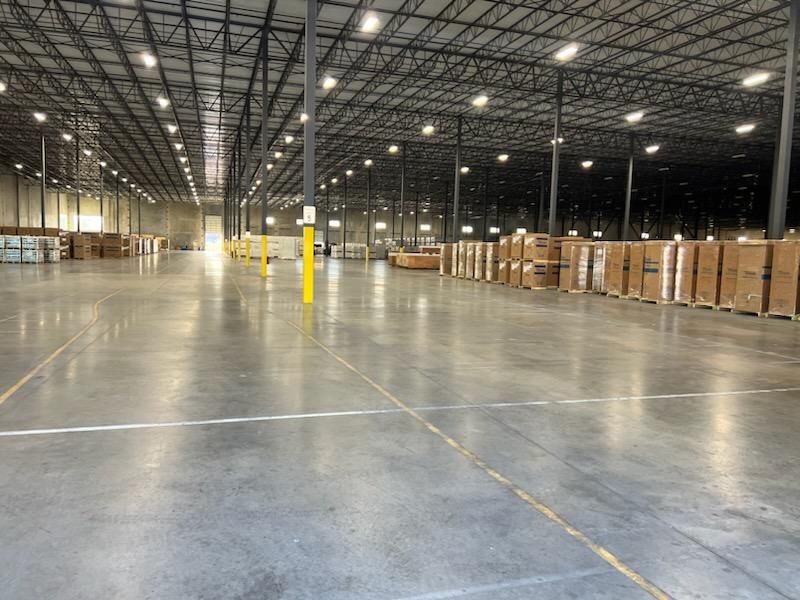 A large warehouse with lots of boxes on the floor