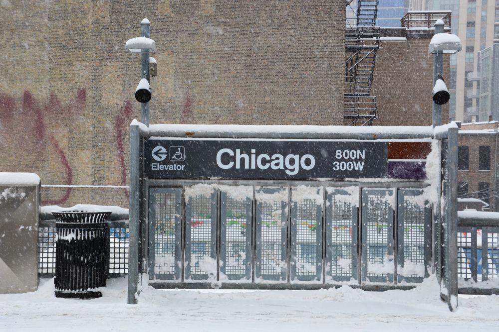 A chicago sign is covered in snow on a snowy day