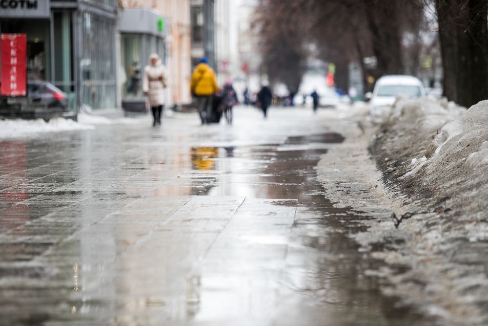 Melted snow on a commercial sidewalk.