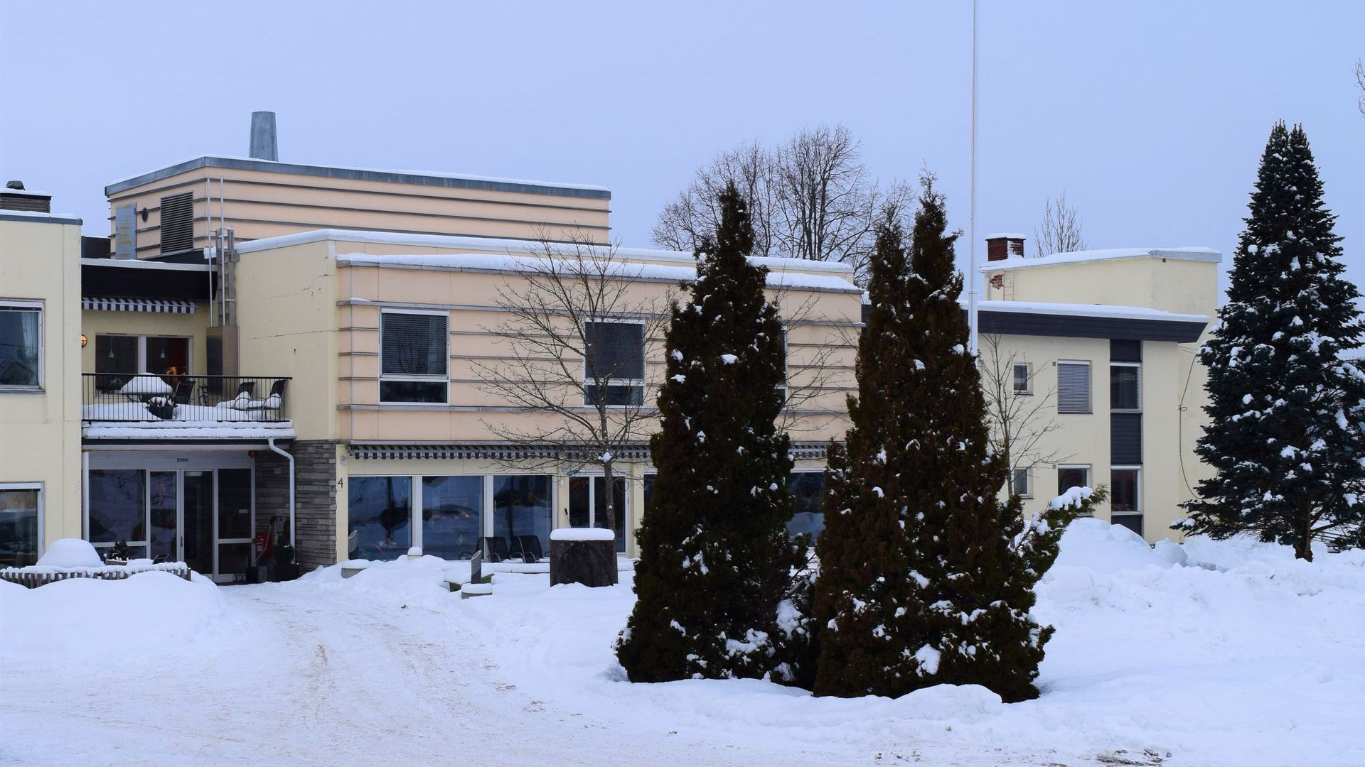A large building with snow on the ground in front of it