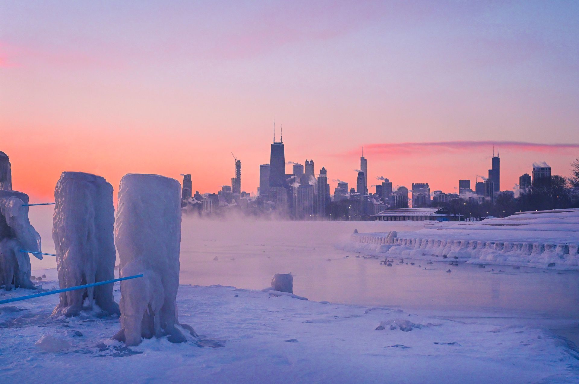 A sunset over a frozen lake with the Chicago skyline in the background.