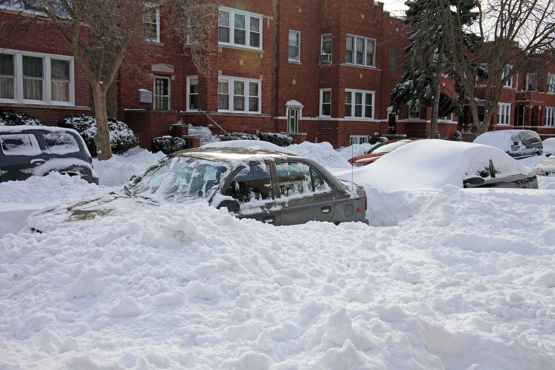 A car is covered in snow in a parking lot