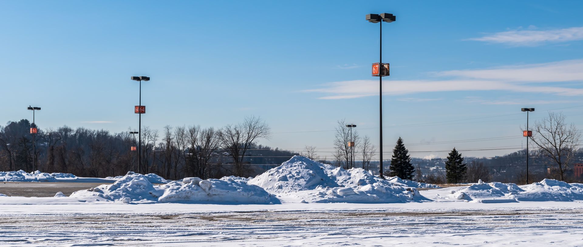 A parking lot covered in snow on a sunny day.