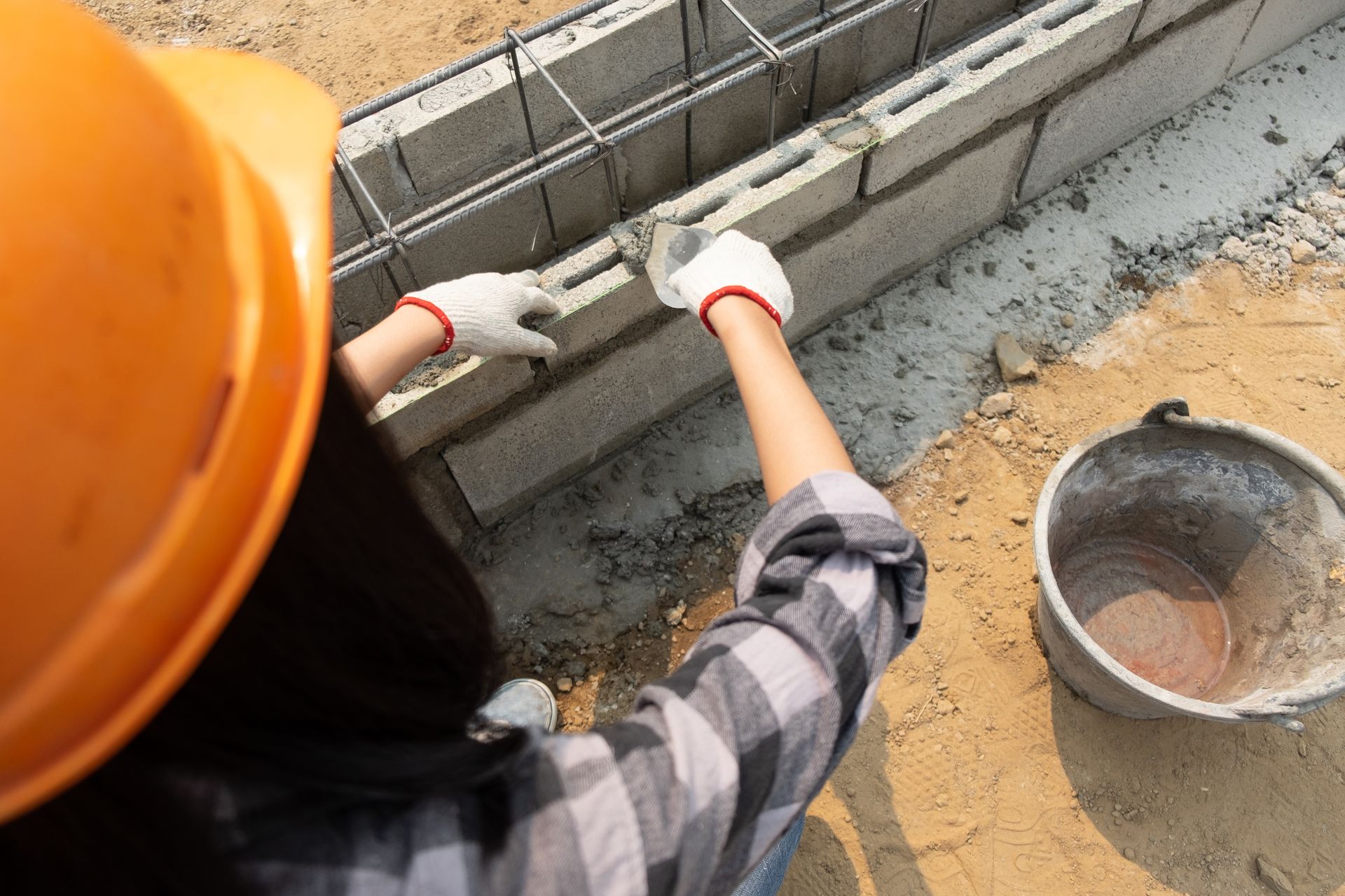 A construction worker is laying bricks on a construction site.