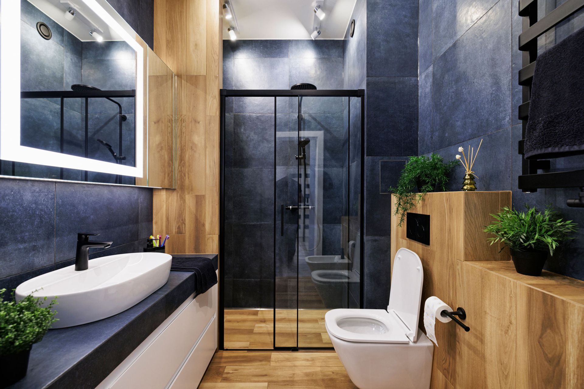 A bathroom with a sink, toilet, shower and mirror.