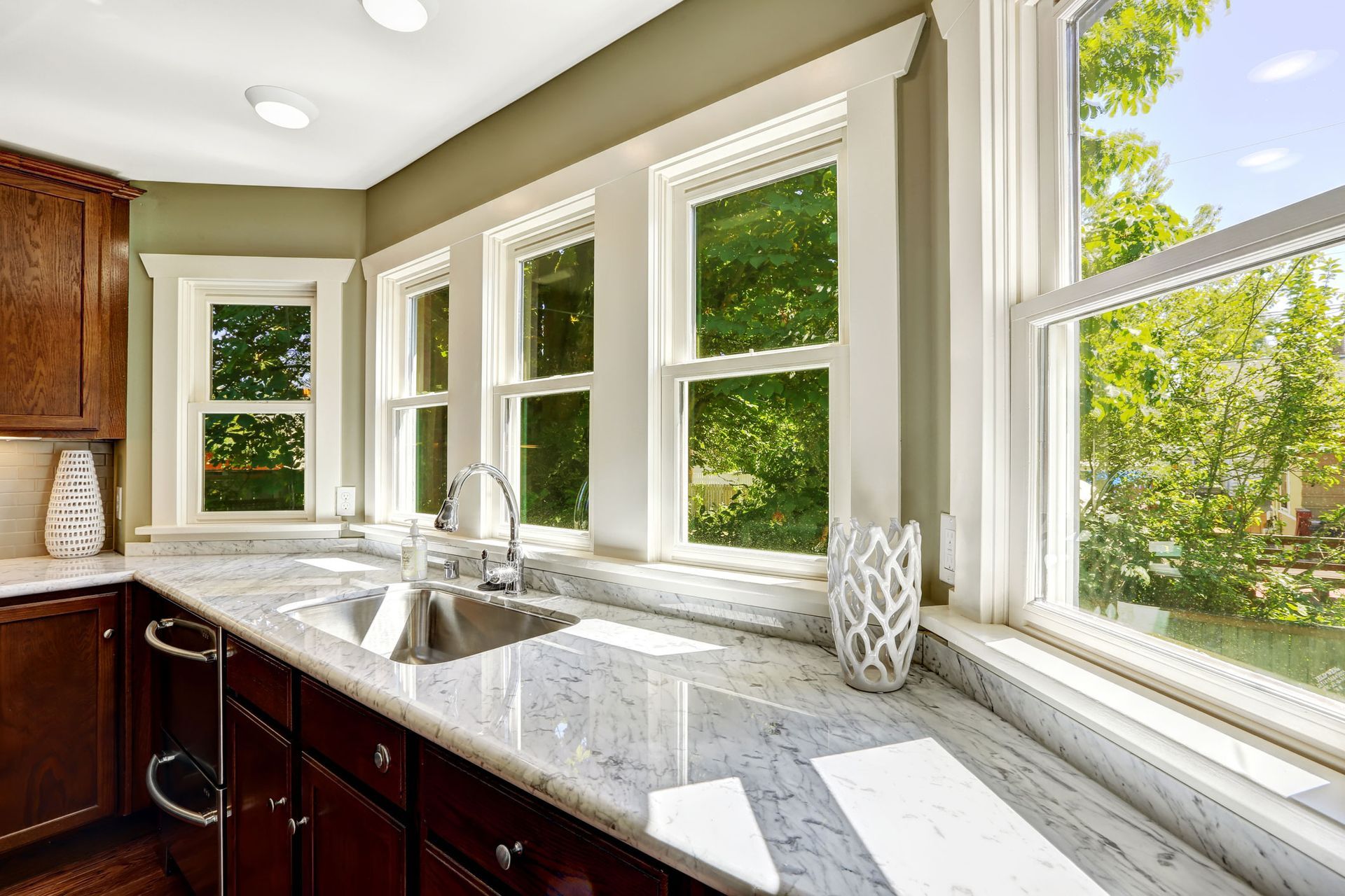 A kitchen with a sink and a lot of windows.