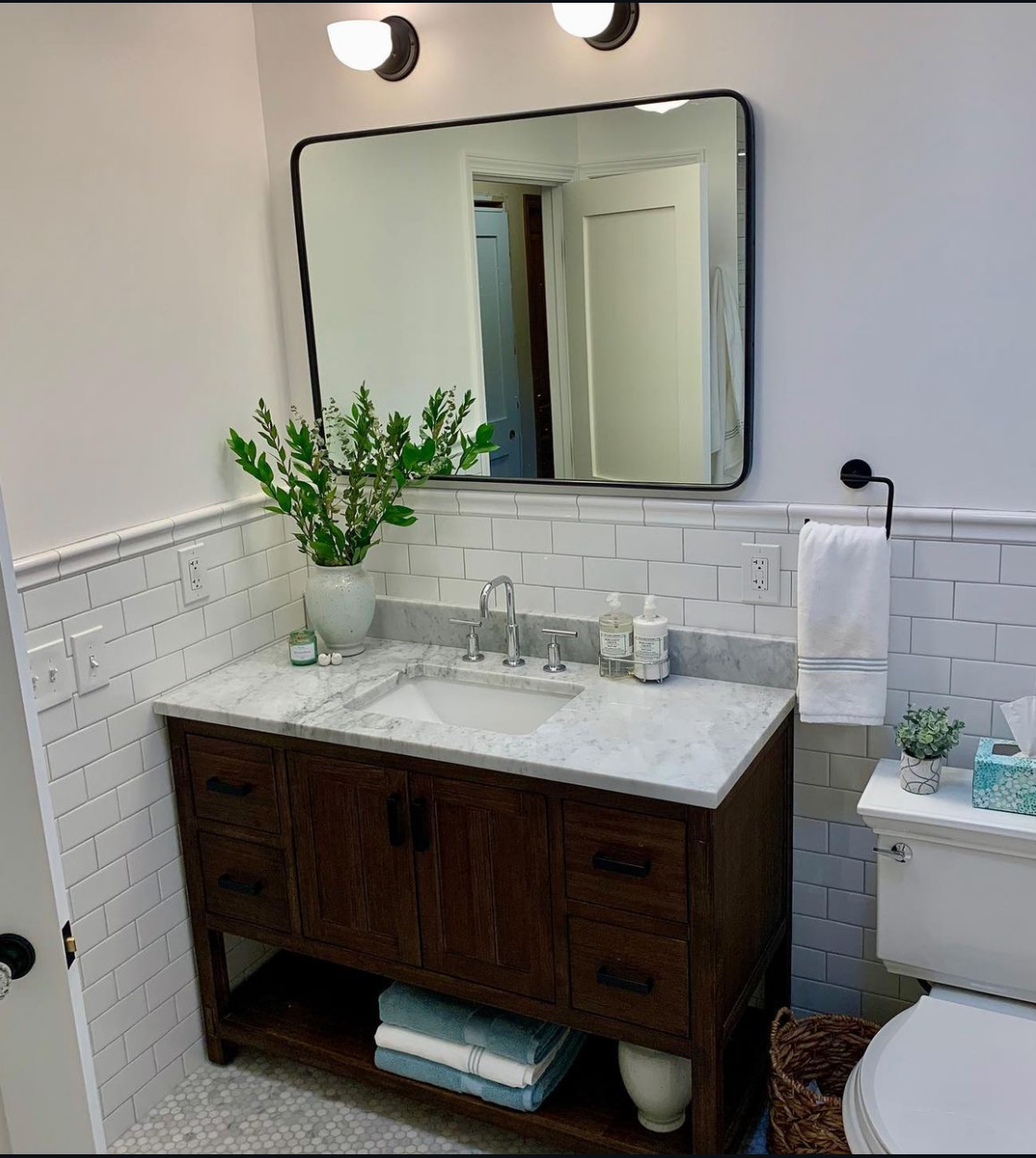A bathroom with a sink, toilet and mirror