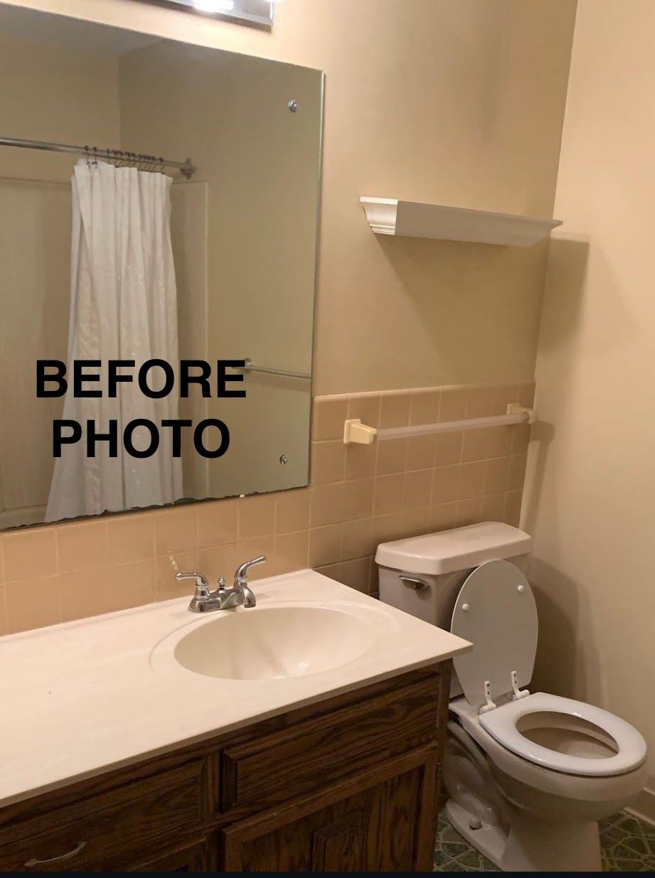 A bathroom with a sink, toilet and large mirror.