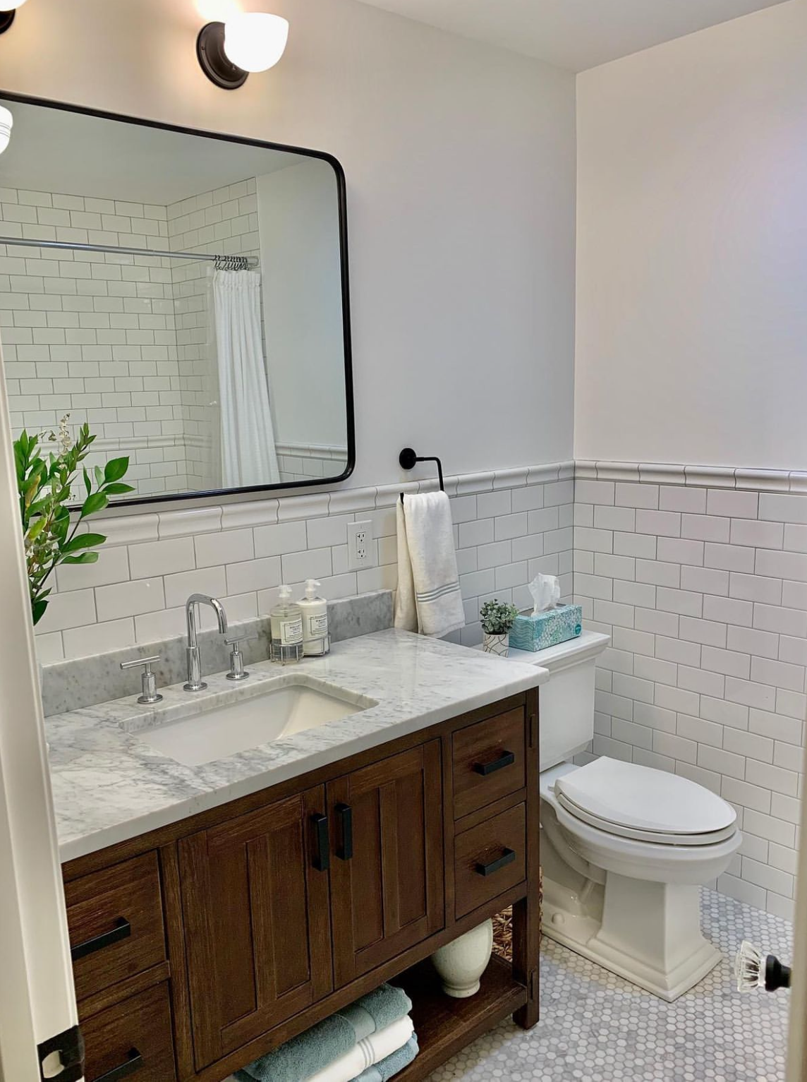 A new bathroom with a sink, toilet and mirror.