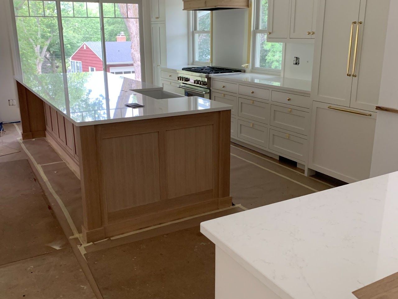 A kitchen with white cabinets and a large island in the middle.