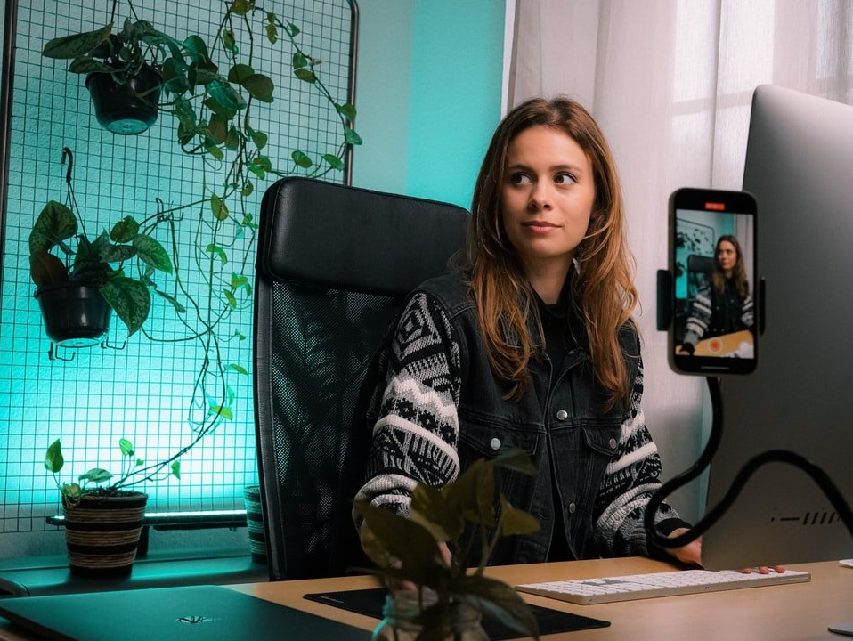 A woman is sitting at a desk in front of a computer.