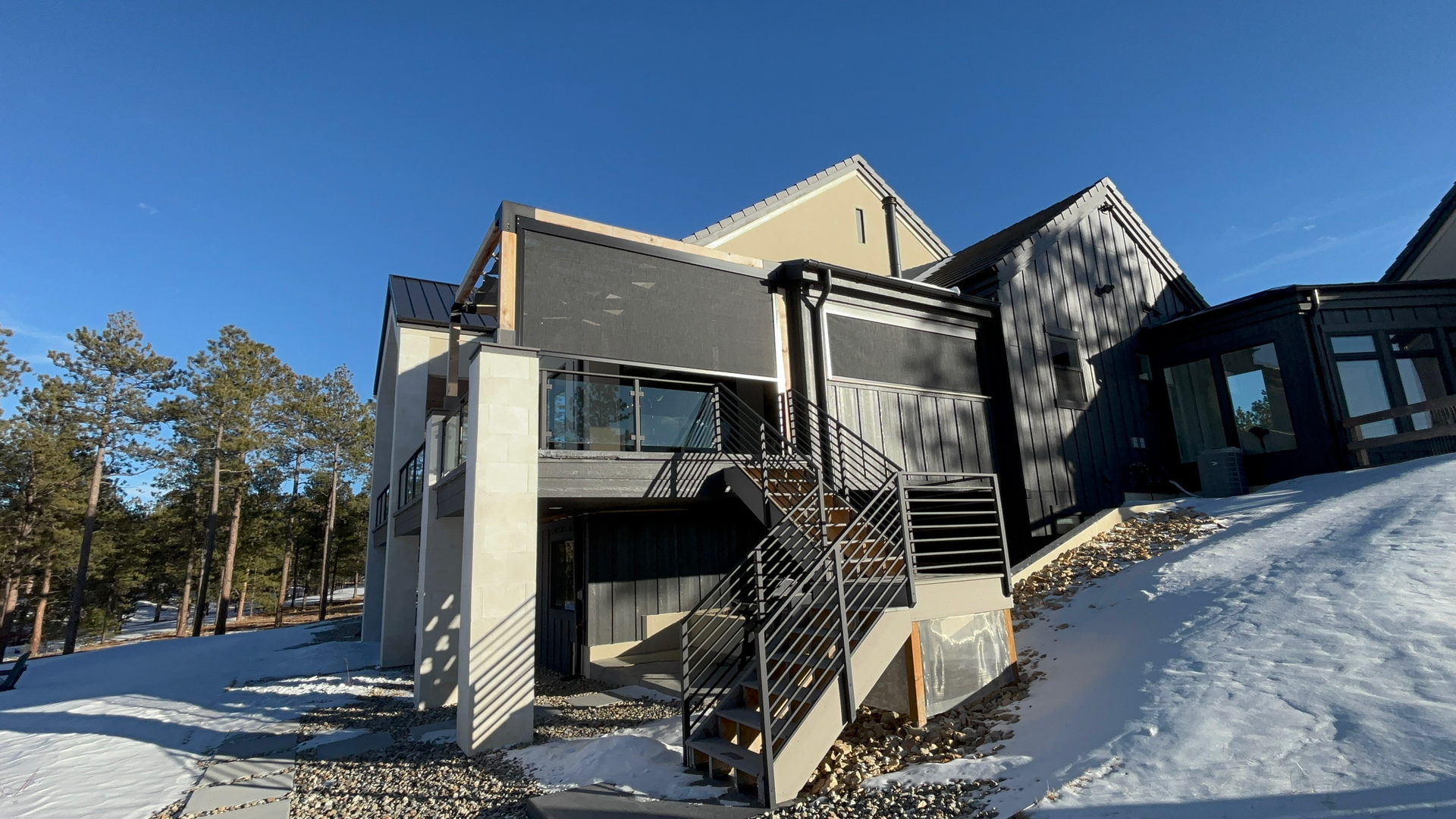 A large house is sitting on top of a snow covered hill.
