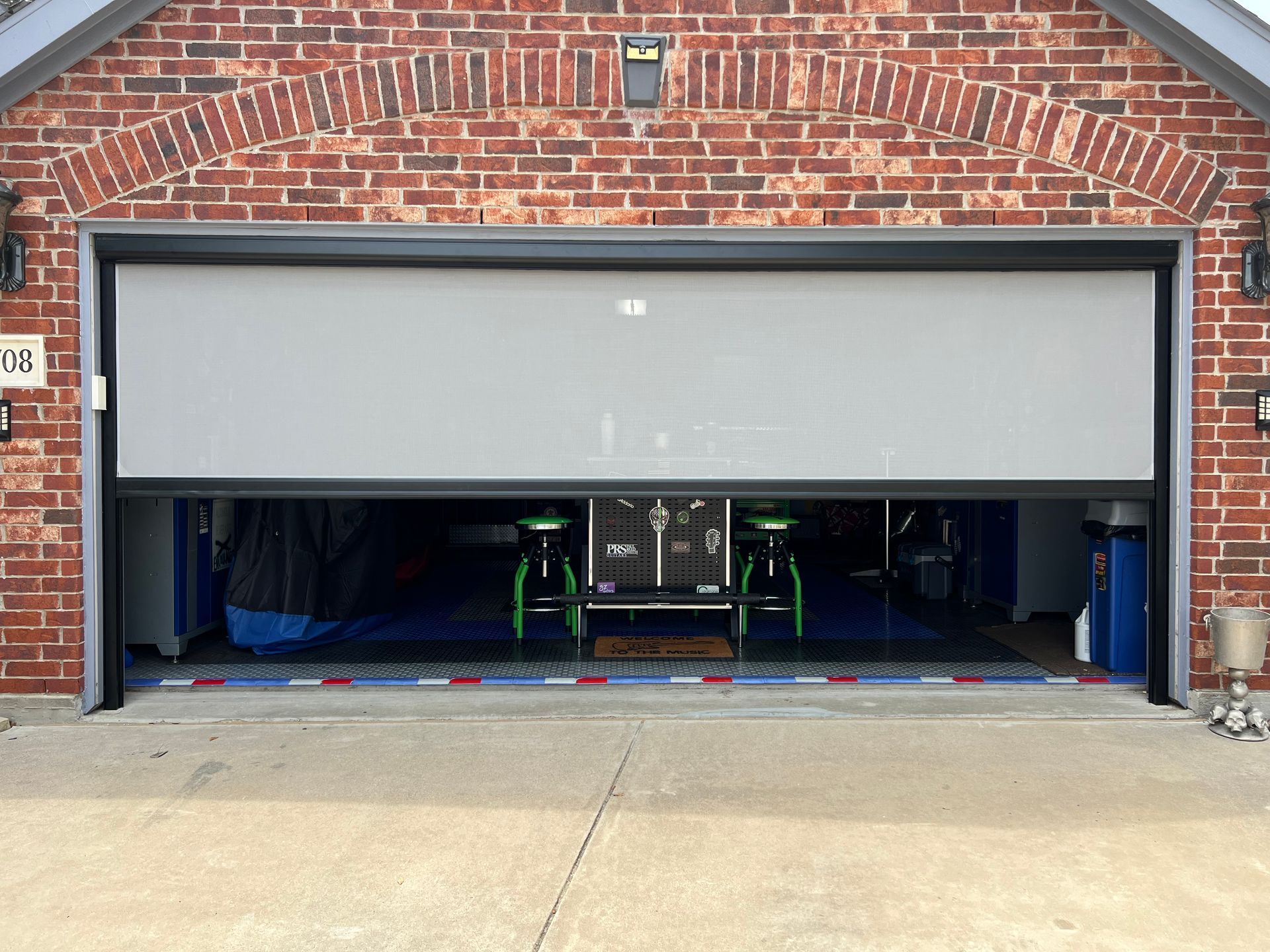 A garage door is open to a room with a table and chairs in it.