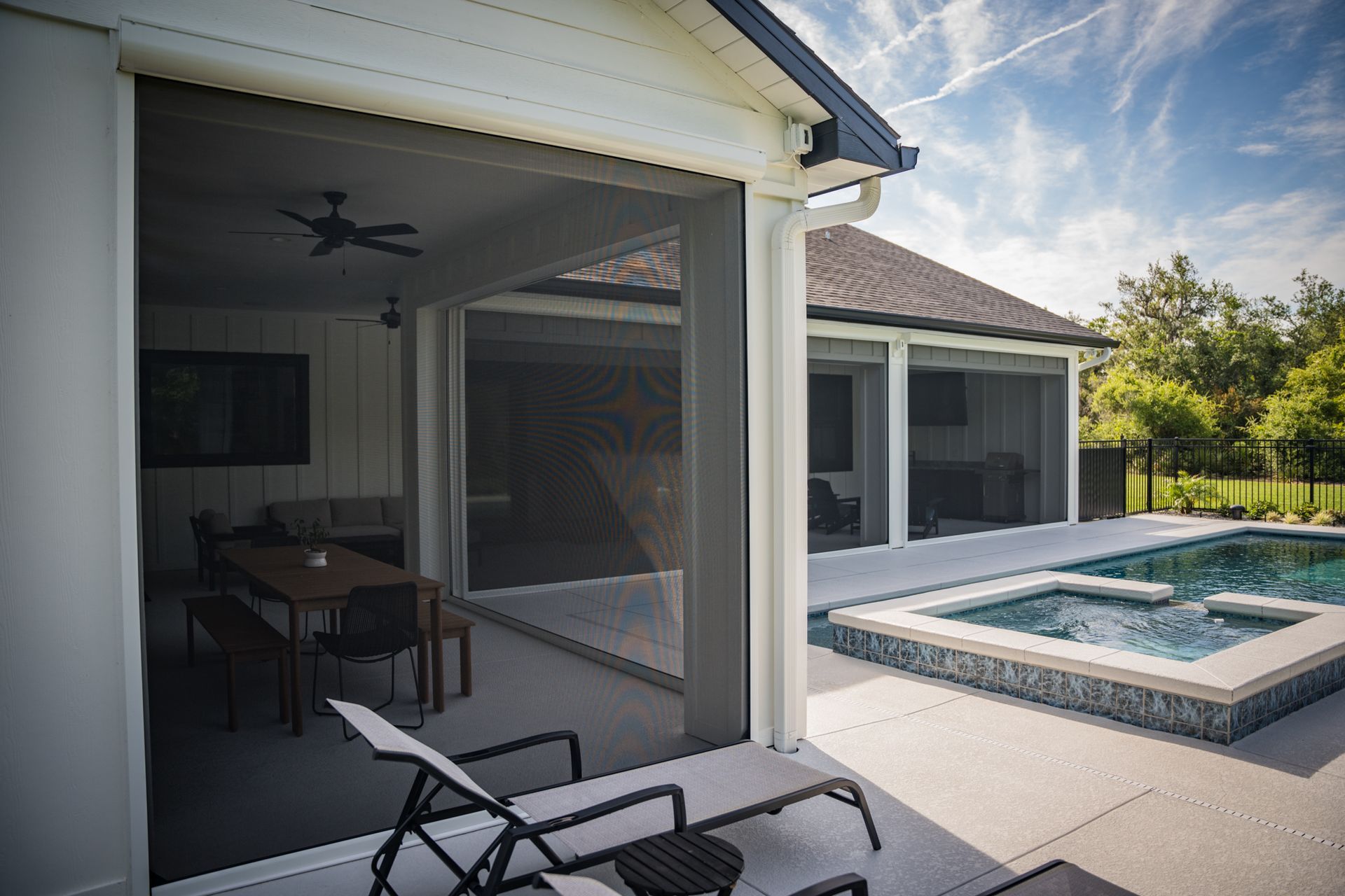 A house with a screened in porch and a swimming pool.