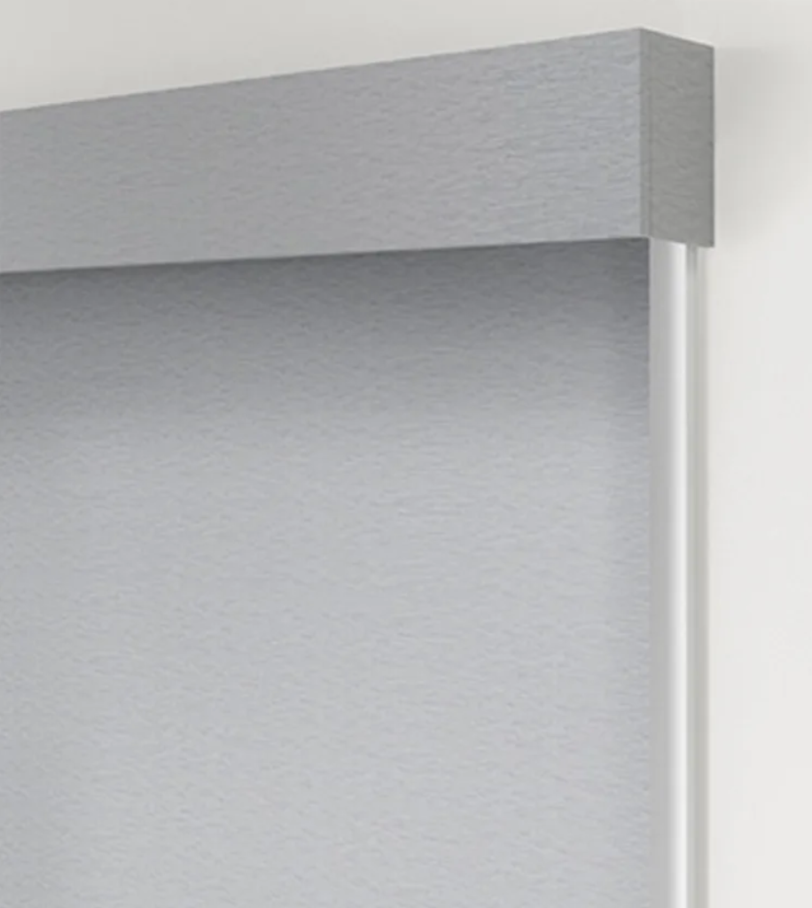 A close up of a gray blind on a white wall.