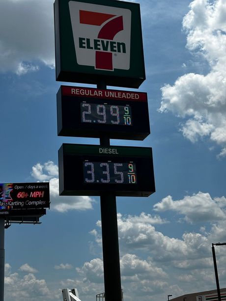 A 7 eleven gas station with a sign that says regular unleaded