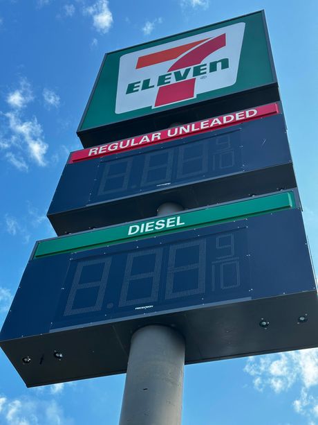 A 7 eleven sign shows the price of regular unleaded diesel and regular unleaded