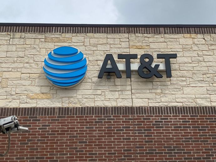 The at & t logo is on the side of a brick building.