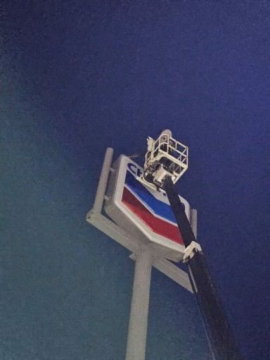 A chevron sign is being lifted by a crane