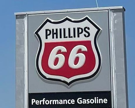 A phillips 66 performance gasoline sign against a blue sky