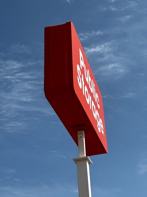 A red sign on a pole that says ' subway ' on it