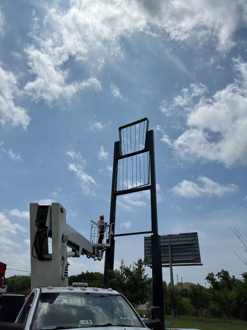 A truck is parked in front of a large billboard