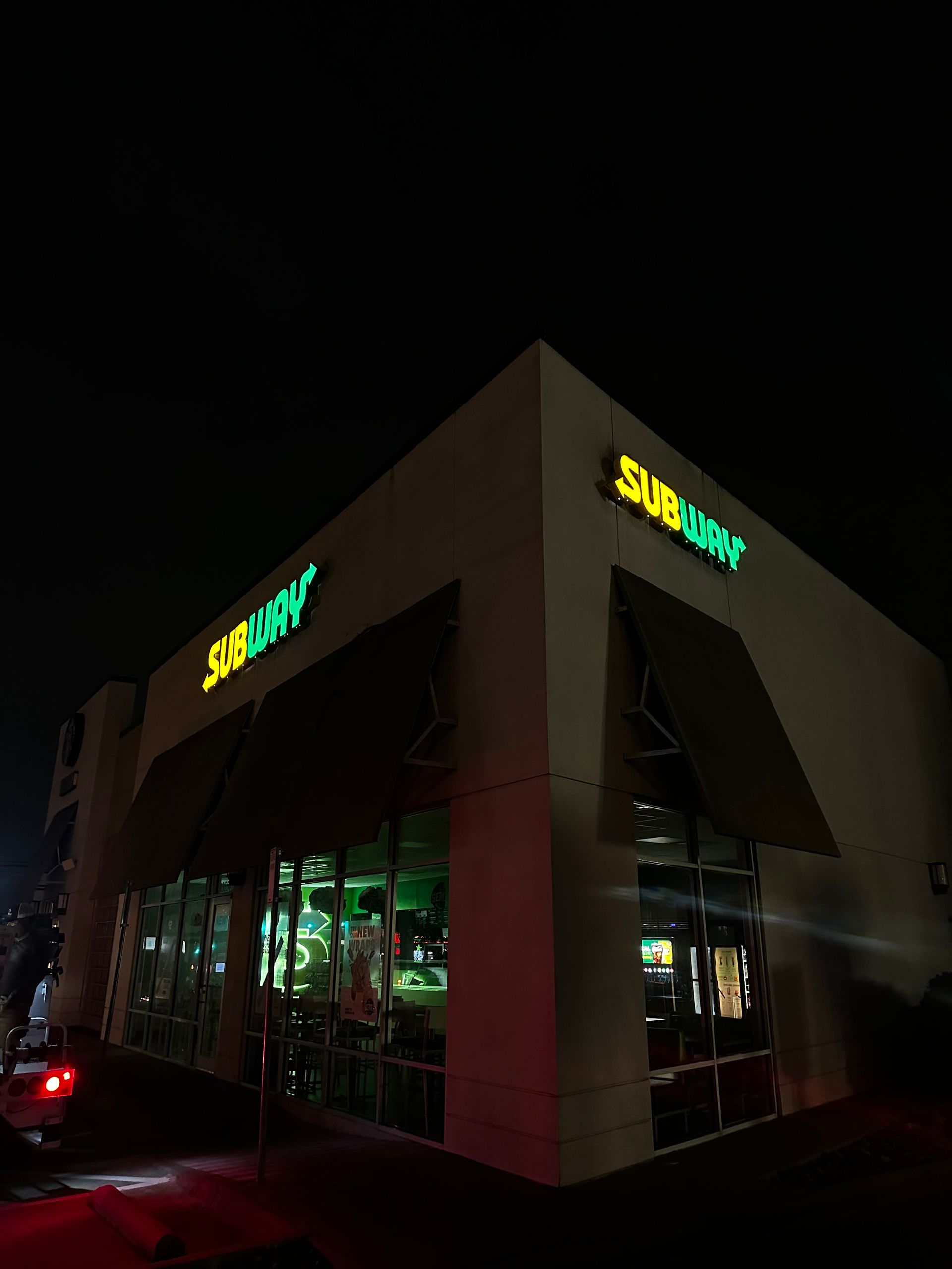 A subway restaurant is lit up at night