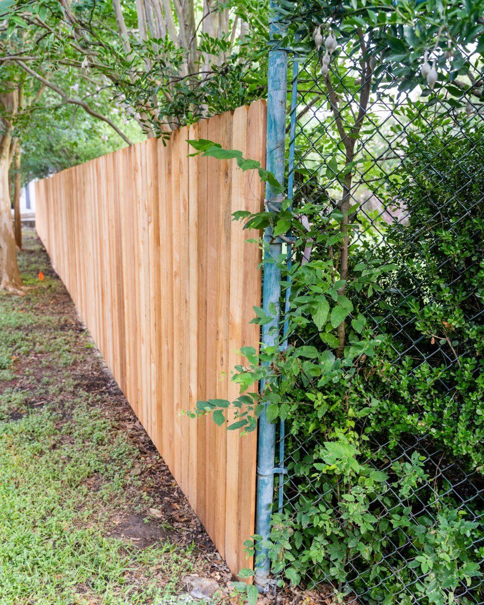 A wooden fence is next to a chain link fence.