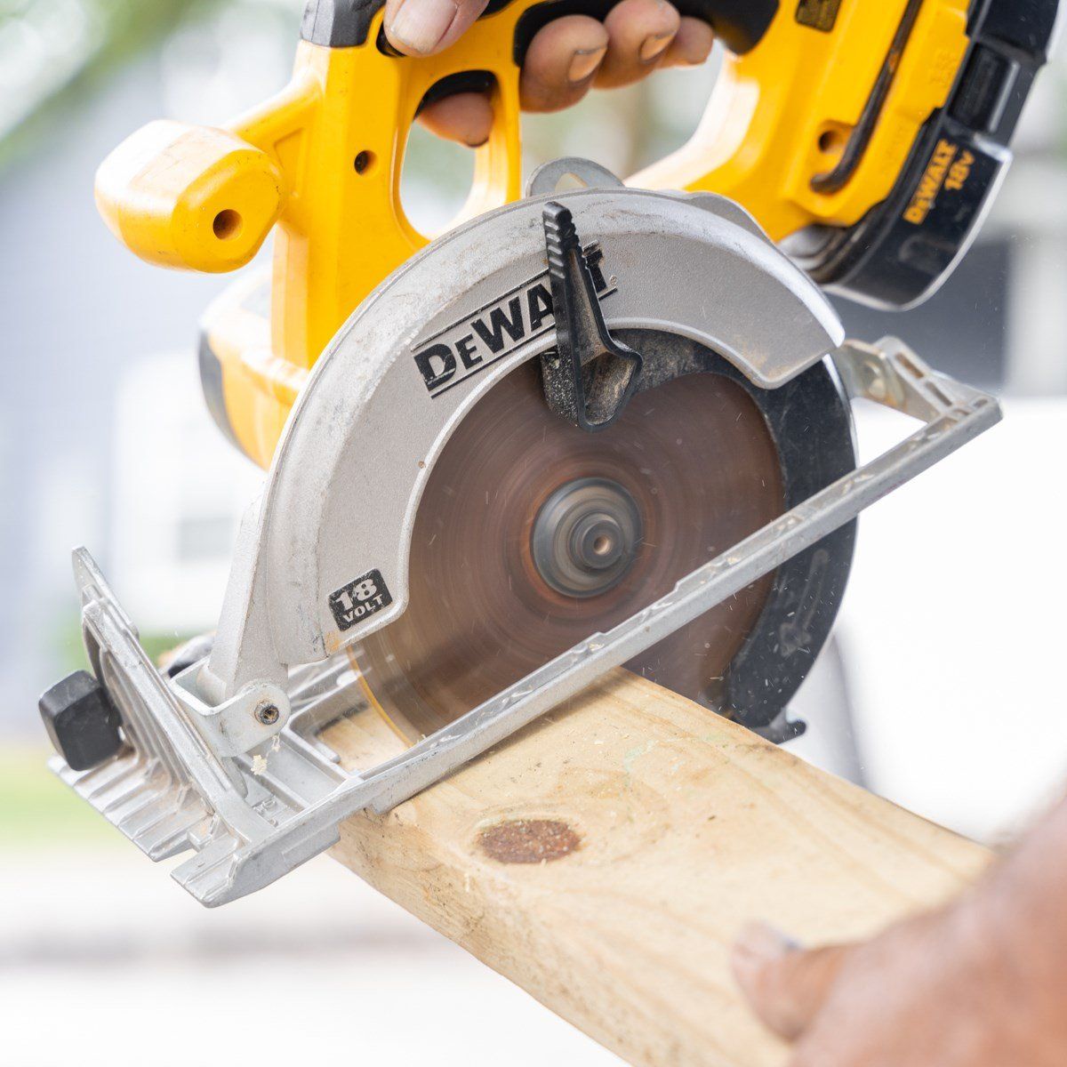 A person is using a dewalt circular saw to cut a piece of wood