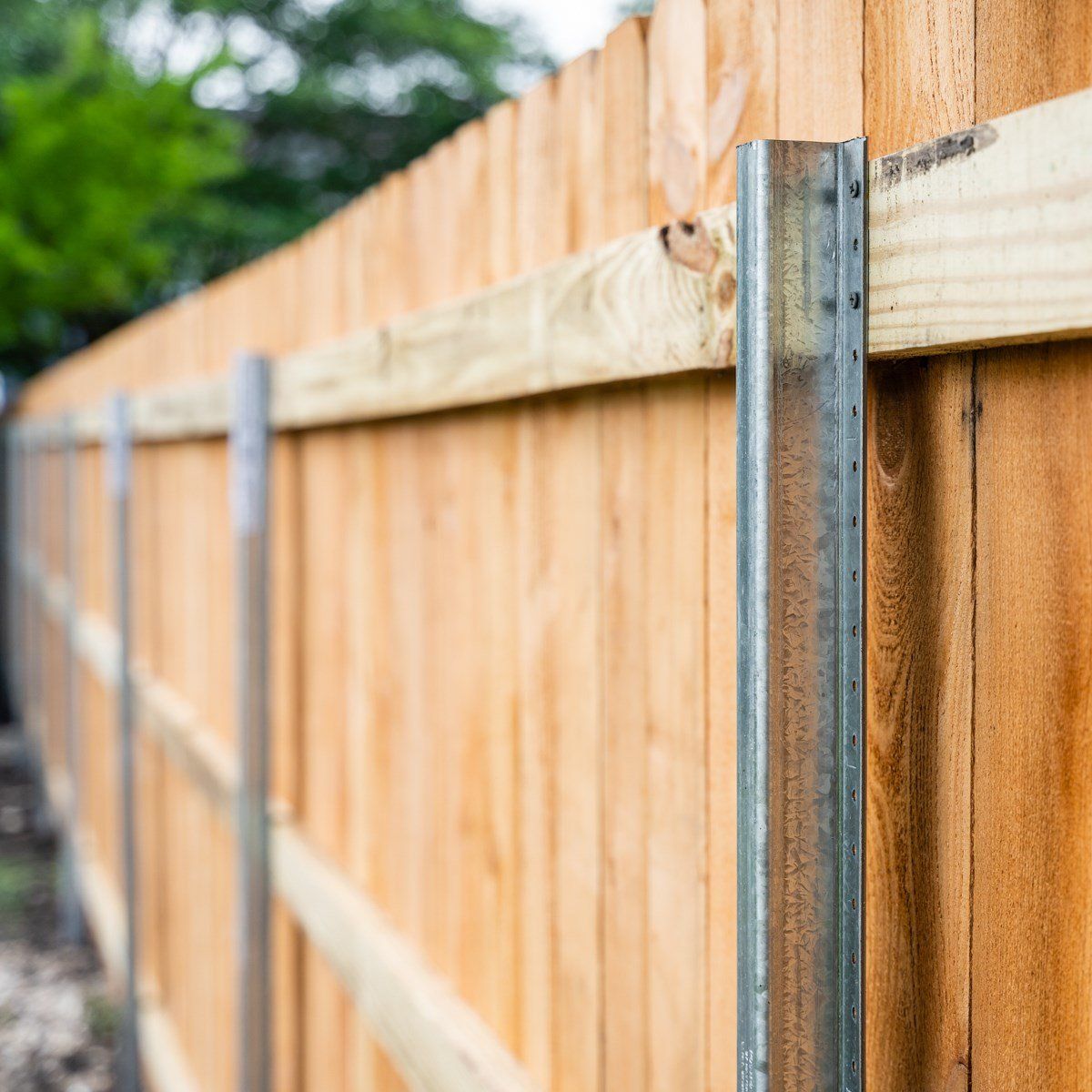 A close up of a wooden fence with metal posts.