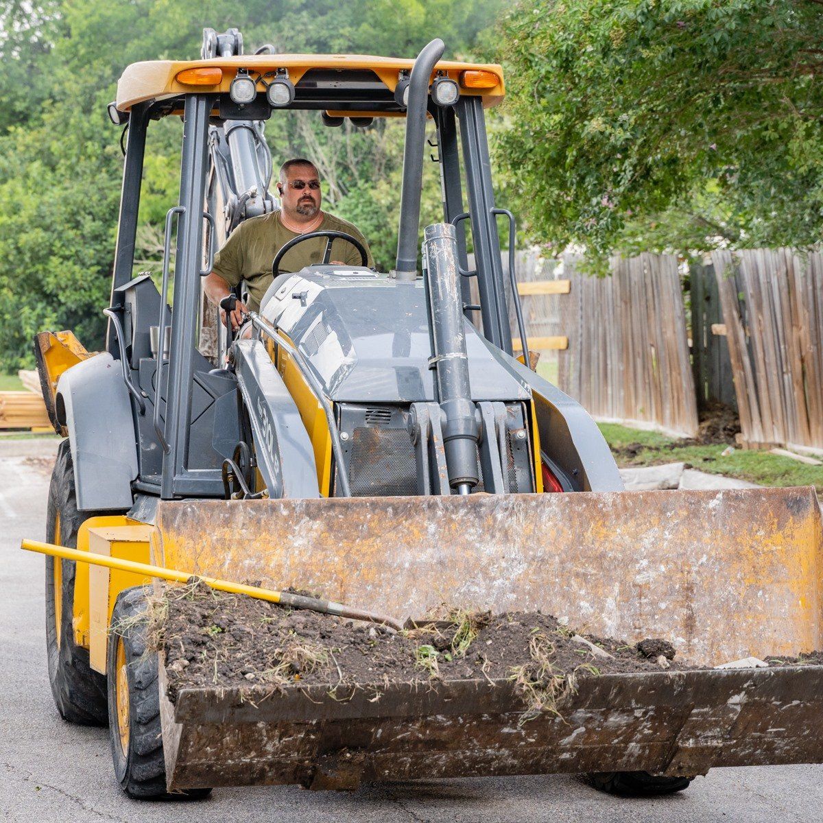 A man is driving a bulldozer on a street