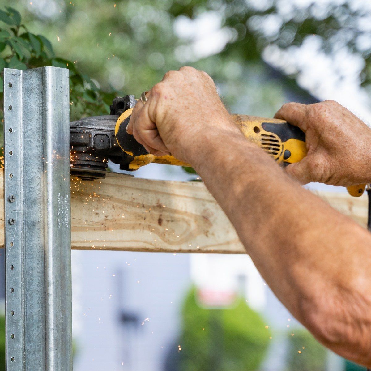 A man is using a circular saw to cut a piece of wood