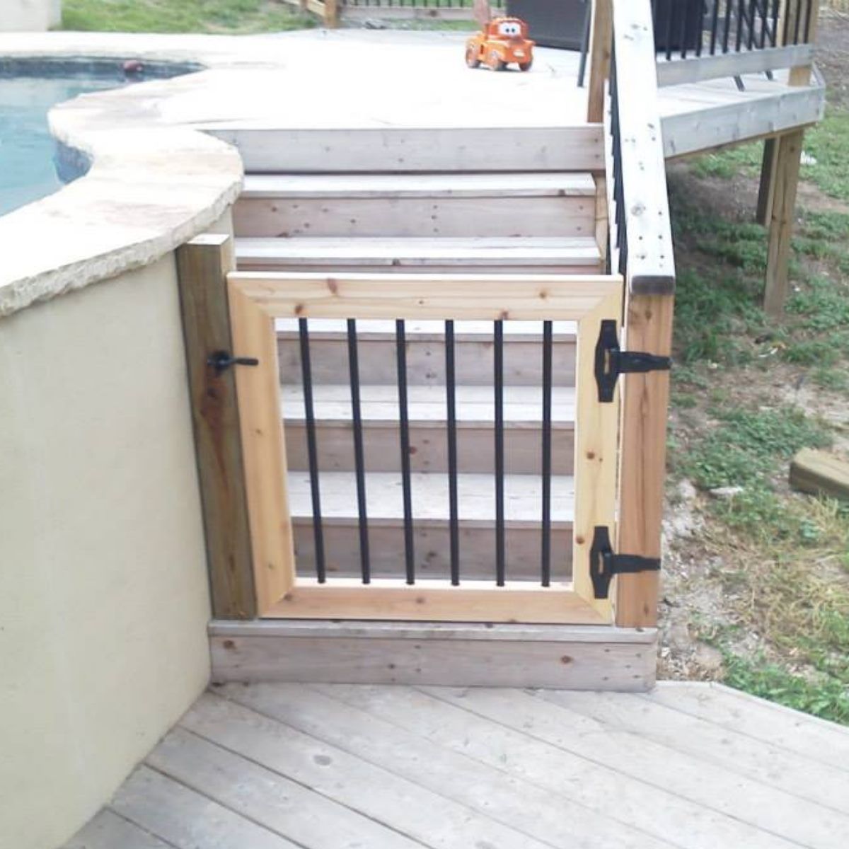 A wooden gate leading to stairs next to a pool