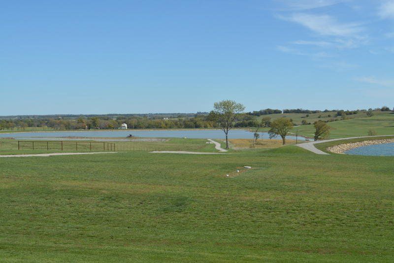 A golf course with a lake in the background