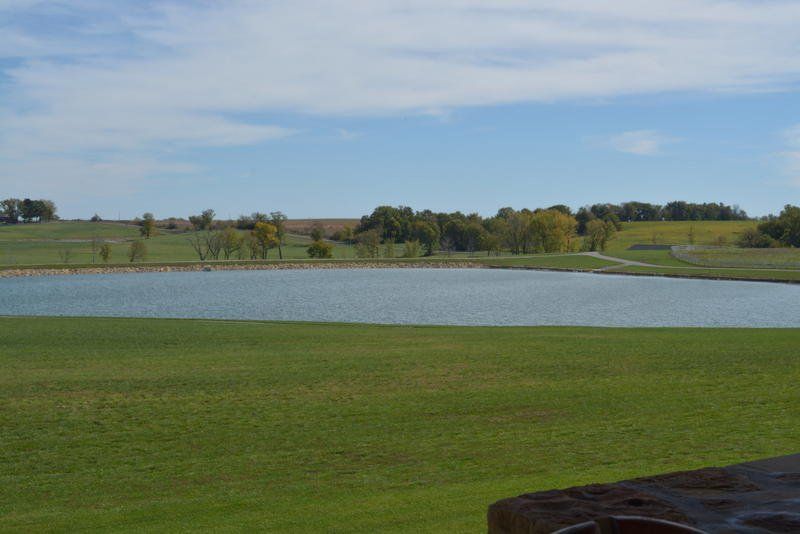 A large body of water in the middle of a grassy field