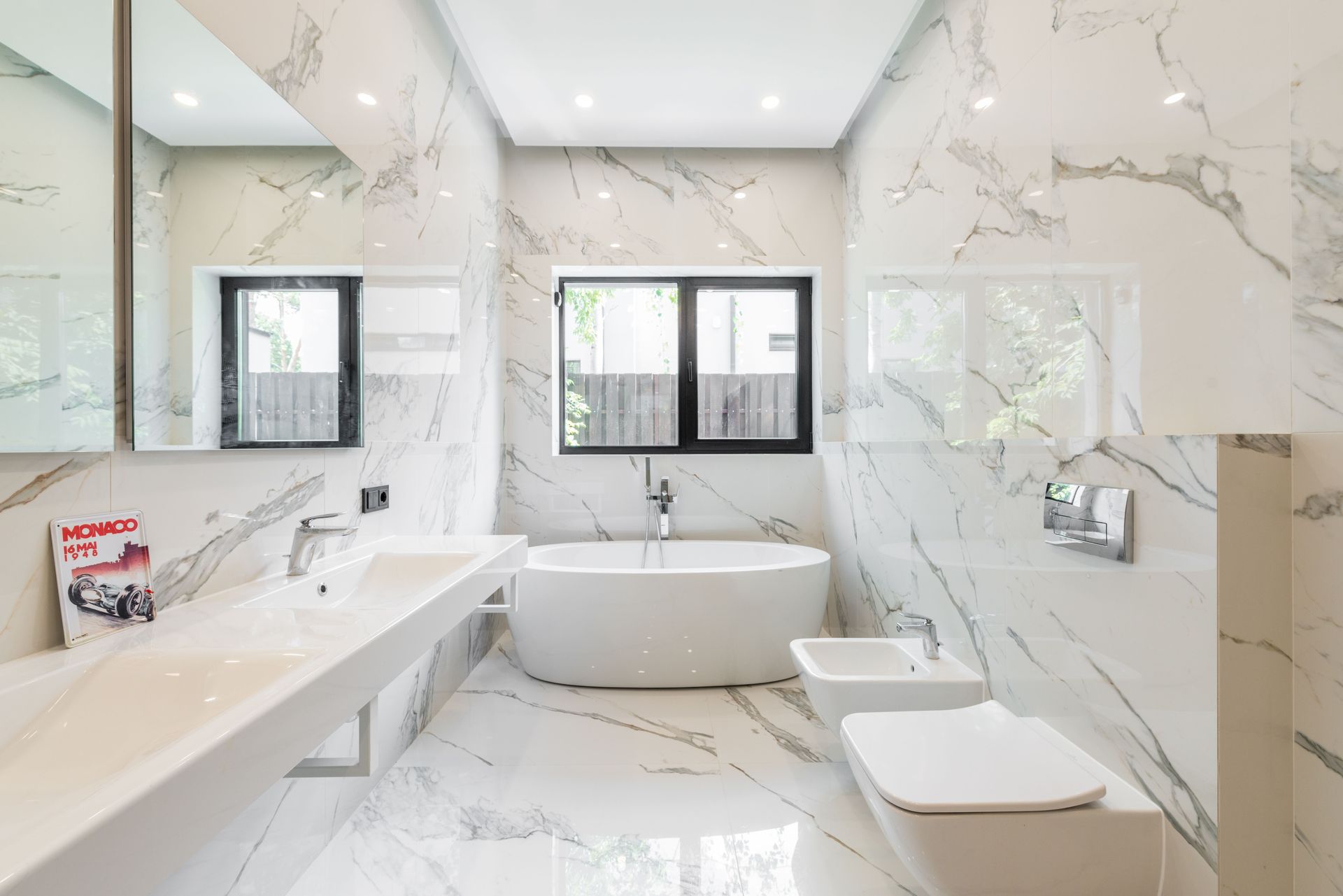 Modern bathroom with glass shower enclosure and a person adjusting the door.