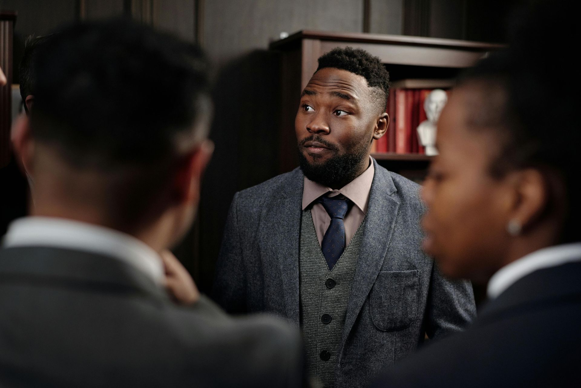 Um homem de terno e gravata está conversando com um grupo de pessoas.