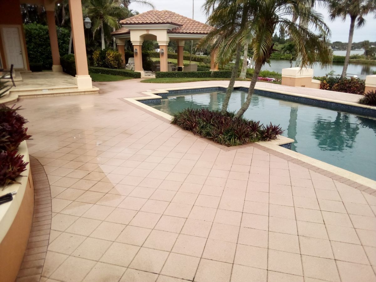 Image showing concrete pool deck area that has been pressure washed by RNR Pressure Cleaning. You can see freshly washed concrete that is still wet on the surface. 