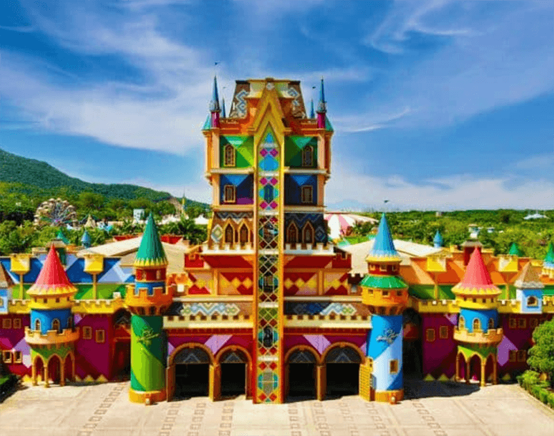 Uma entrada colorida com um castelo de várias torres no parque temático Beto Carrero World, sob um céu azul claro.
