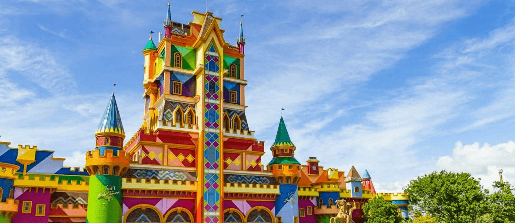 A entrada do castelo fantástico, colorido e com múltiplas torres, no parque temático Beto Carrero World, sob um céu azul brilhante.