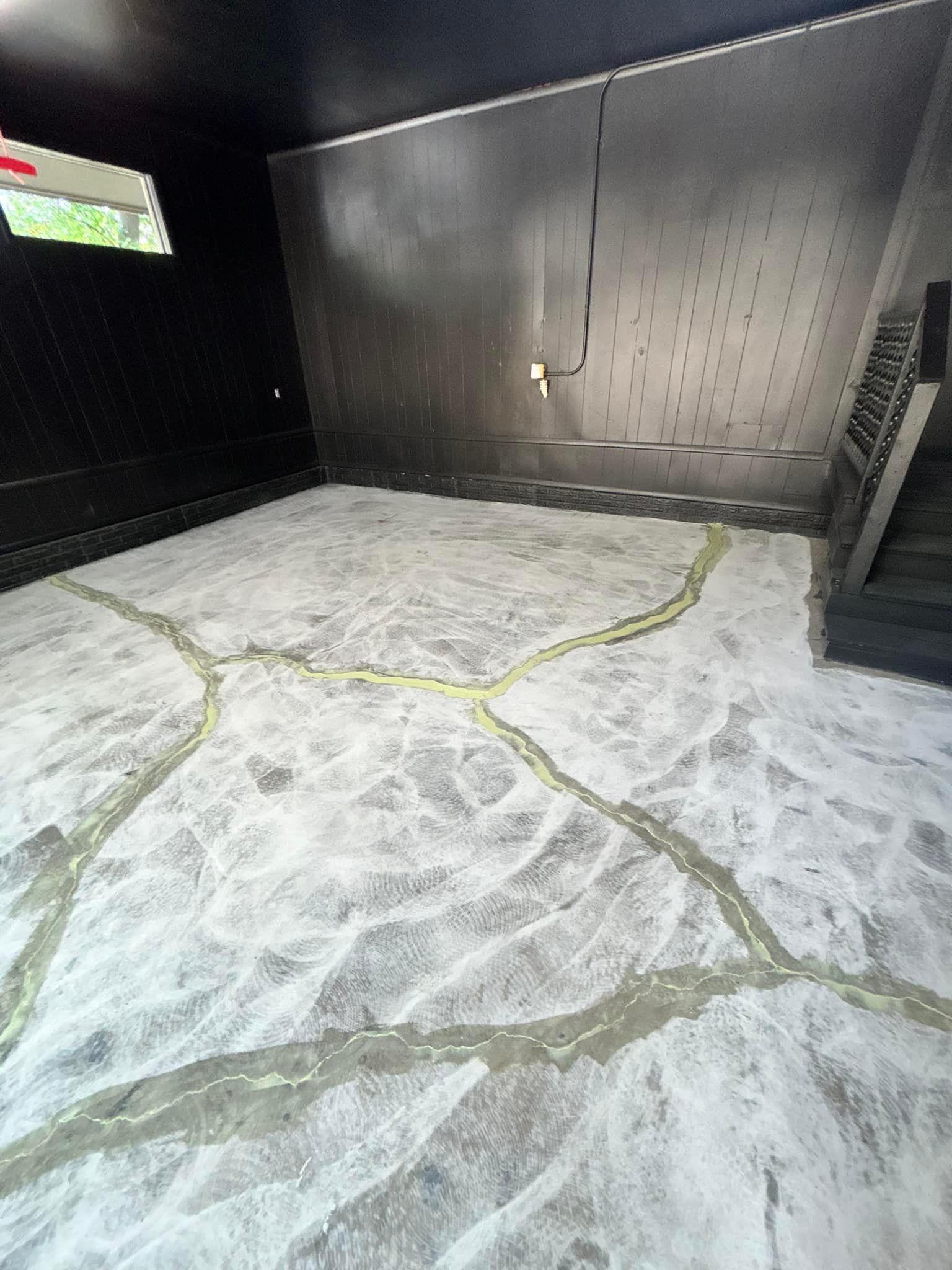 Empty black-walled room with a white marbled floor and a small window on the left.