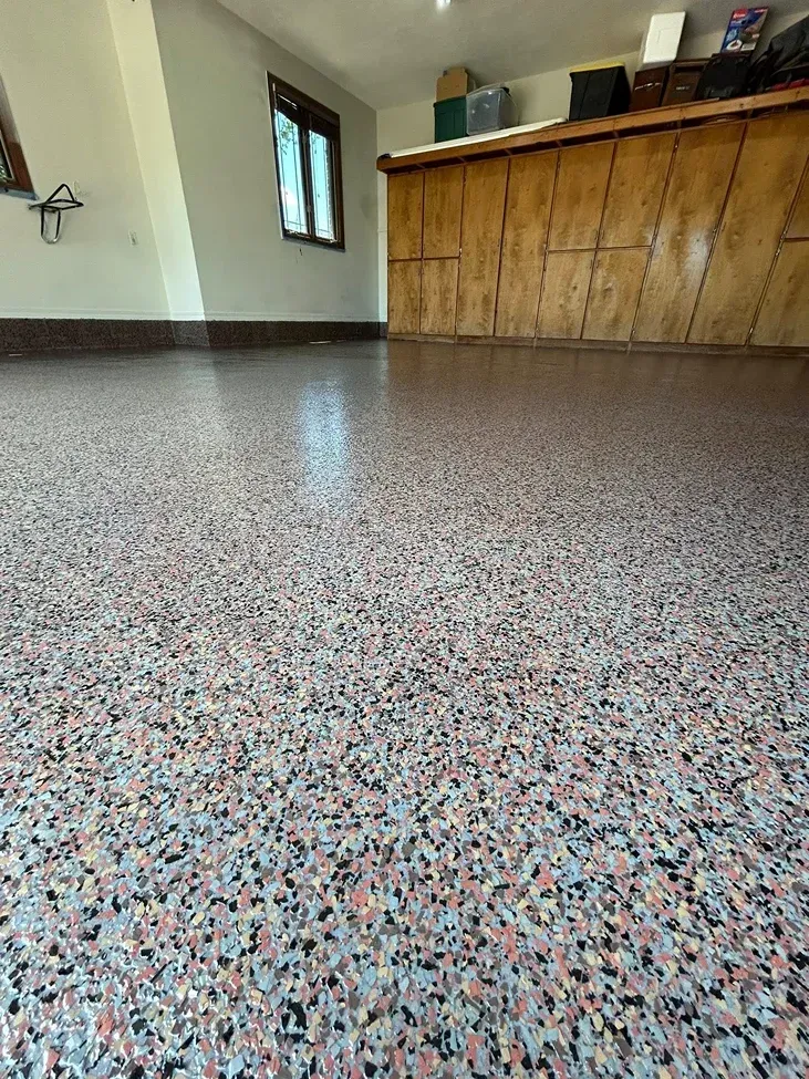 Speckled terrazzo floor in a room with a wooden counter and small window.